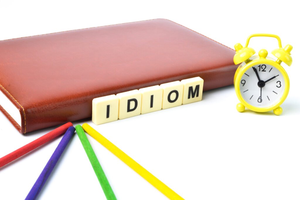 Scrabble letters with text IDIOM over white background.